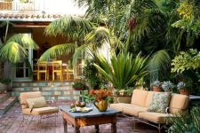 reclaimed bricks in various sizes bring been-around-awhile appeal to an antique-furnished patio positioned amid tropical foliage