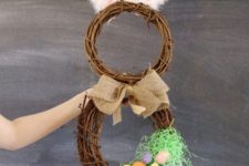 03 a grapevine bunny wreath with fluffy ears, a burlap bow and faux eggs