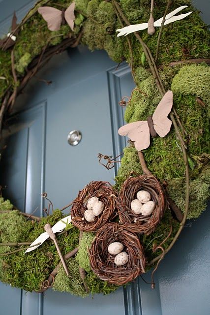 moss covered wreath with paper butterflies and nests