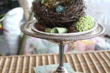 08 a silver stand with a grapevine nest, fern and a blue egg