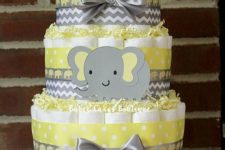 10 yellow and grey disaper cake with ribbon bows and an elephant