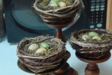 11 grapevine bird nests with speckled eggs on vintage wooden and metal stands