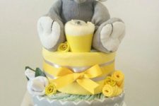 11 yellow and grey nappies cake with a stuffed elephant on top