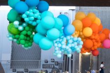 13 oversized rainbow balloon installation over the table
