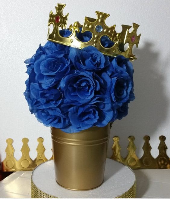 a gold bucket with paper roses and a crown for a prince-themed shower