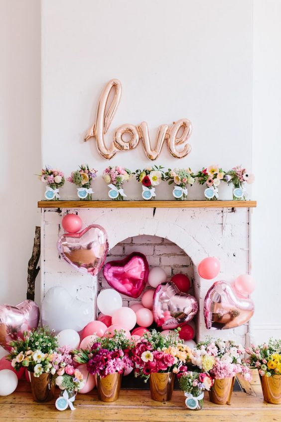 lots of pink balloons and LOVE letters over the faux fireplace