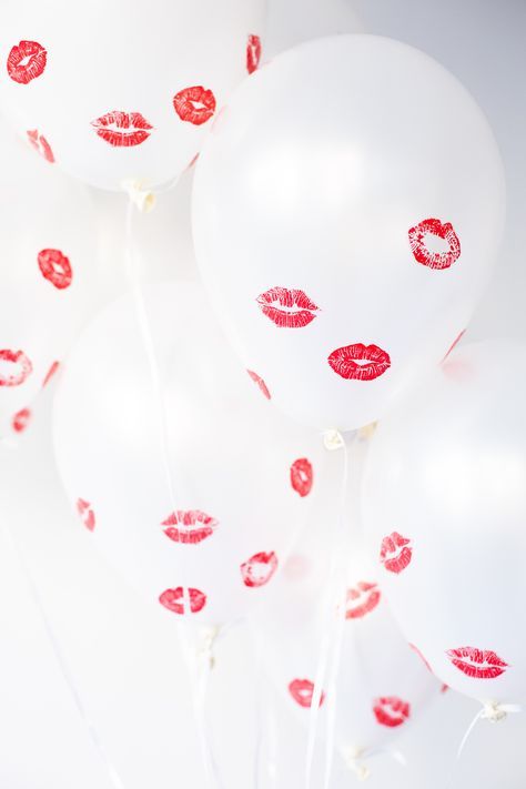 take white balloons and kiss them using a red lipstick