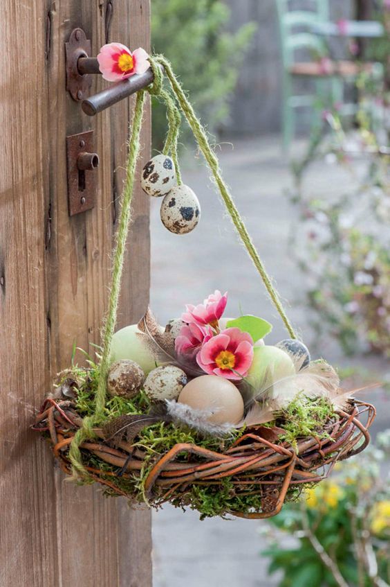 a bright Easter decoration of a nest with moss, pastel and speckled eggs and bright blooms is a cool solution