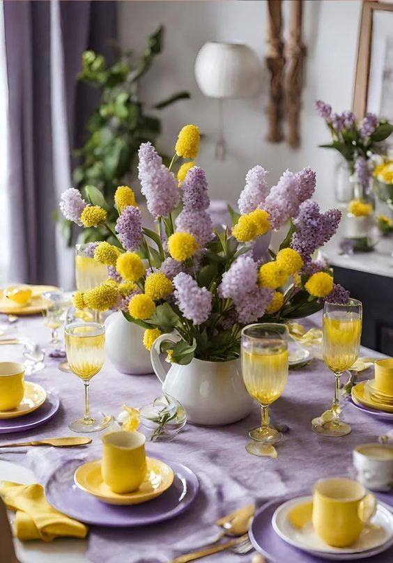 a bright spring or Easter tablescape in lilac and yellow, with fresh blooms, lilac plates and a tablecloth and yellow porcelain