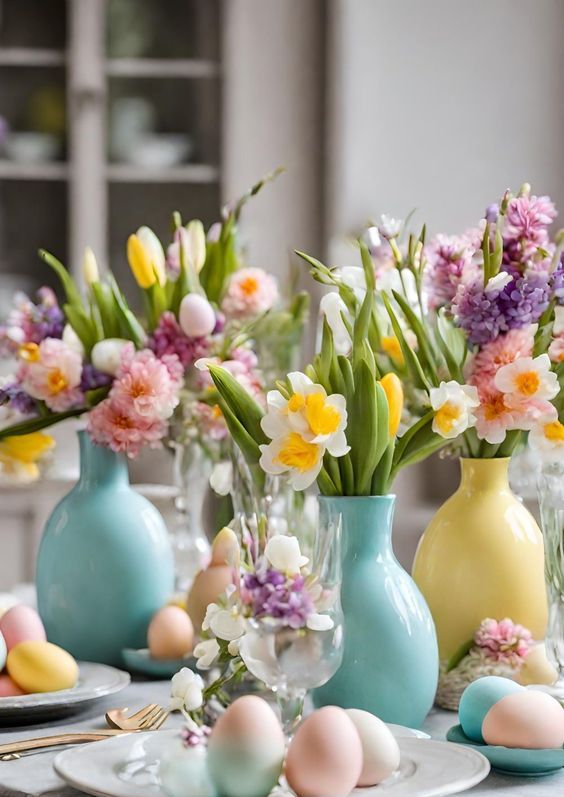 a colorful modern Easter table setting with blue and yellow vases with spring blooms and colorful and pastel eggs is super cool