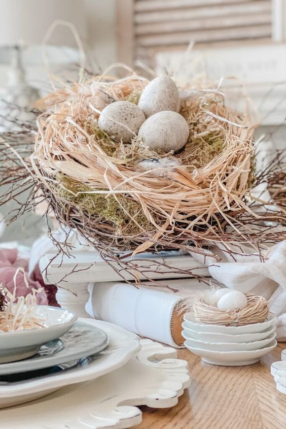 a neutral centerpiece of a nest with vine, hay and moss and fake eggs is a cool idea for Easter
