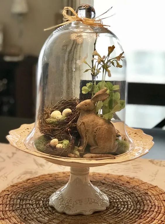 a vintage Easter terrarium with nests and eggs, greenery and a bunny is a cool idea for an Easter farmhouse space