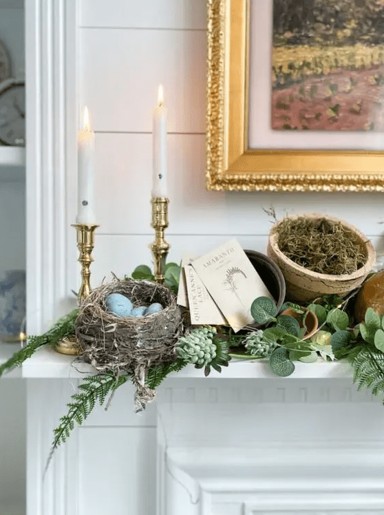 a woodland Easter mantel with greenery, lights, a faux nest with blue eggs, candles, moss in a planter is fab