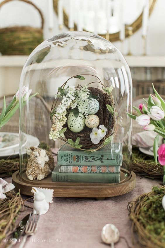 an Easter terrarium with books, a nest with blooms and eggs and a bunny is a fun and cool decoration to rock
