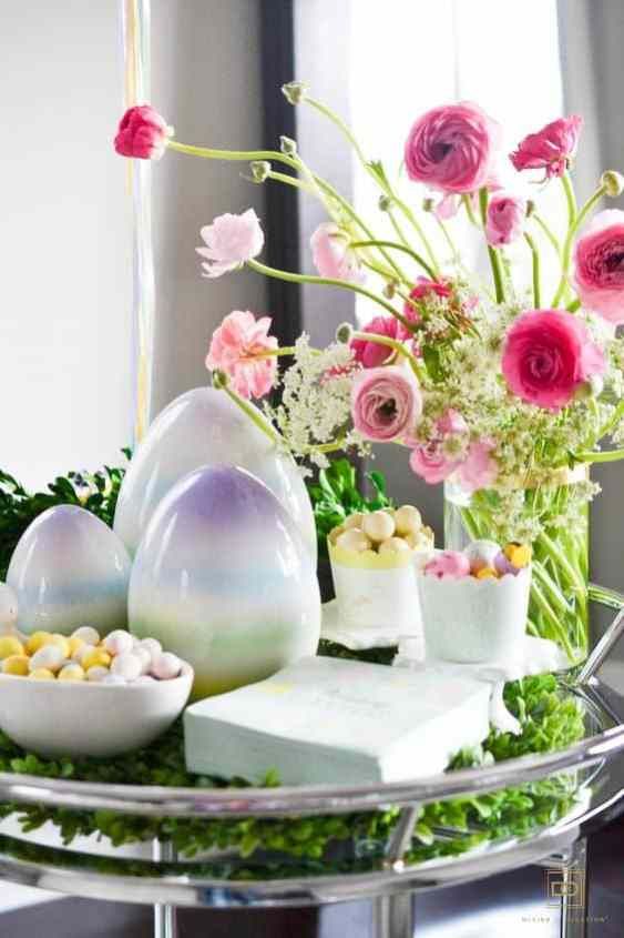 modern Easter decor with bright blooms, pastel oversized eggs and pastel candies plus greenery decor