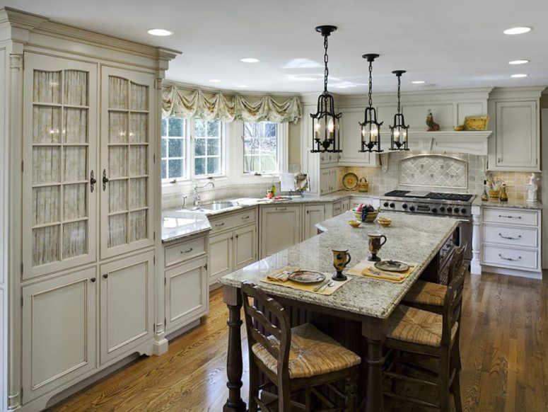 off-white cabinets and a backsplash, marble countertops add interest to the kitchen