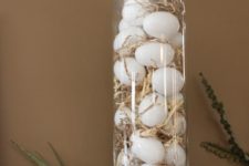 03 an apothecary jar filled with straw and white eggs