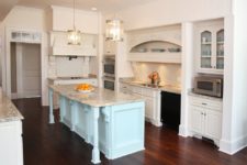 05 a white kitchen with a mint kitchen island and grey marble countertops