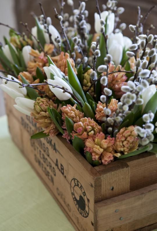 a wooden crate with fresh spring blooms and willows