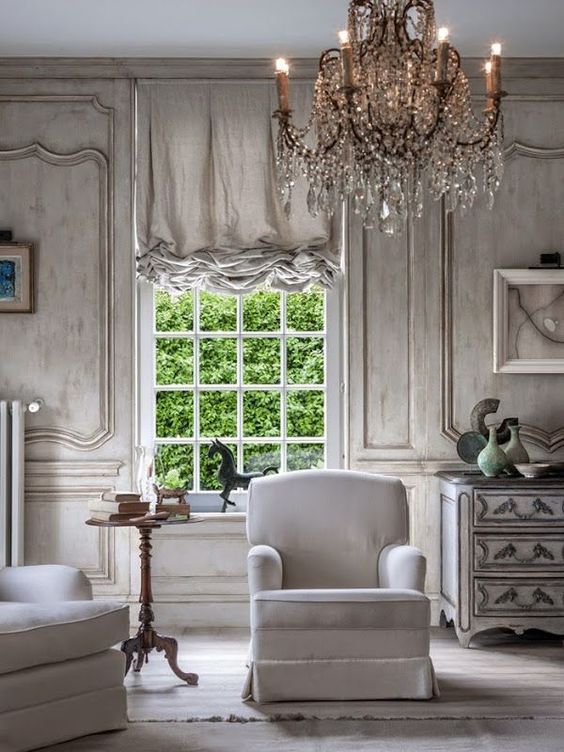 oversized crystal chandelier makes a statement in this whitewashed room