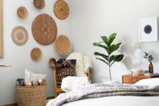 11 wall baskets and a storage one are used to emphasize the boho style of the bedroom