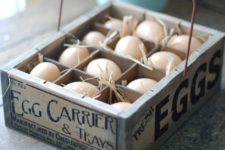 12 the wooden egg crate features a vintage style company logo, wire handle, and one dozen plastic eggs nestled in straw