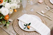 12 this tablescape is accentuated with creamy and orange flowers, fruit and a wicker placemat