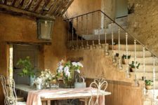 large farmhouse table and white forged chairs, a large lantern over them