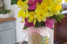 16 a mason jar with colorful candies and some bold fresh flowers