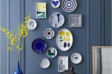 16 colorful plates arrangement on a dark blue wall