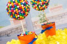 16 orange buckets filled with colorful candies and gumball topiaries
