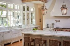 16 wooden beams with hanging lanterns and wicker chairs add interest and coziness to the kitchen