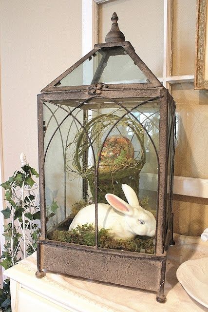 a large vintage lantern with a basket and a dyed egg and a white bunny