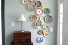 17 curved colorful plate arrangement in an entryway, with different patterns and images
