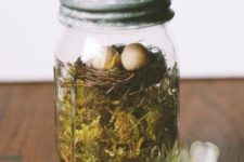 18 a mason jar with moss and a faux bird nest is a cool Easter terrarium