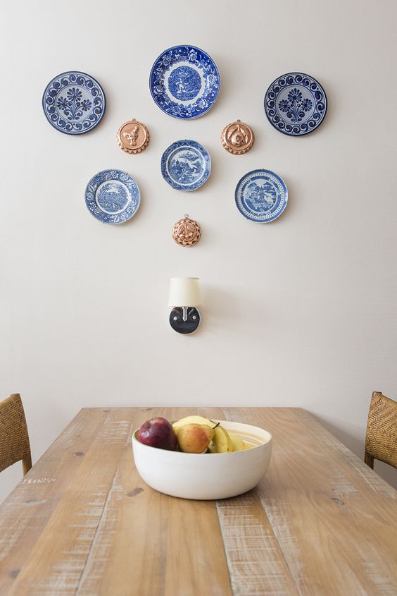 a blue plate wall in the dining room is a stylish decor idea that will bring some color and interest to the space