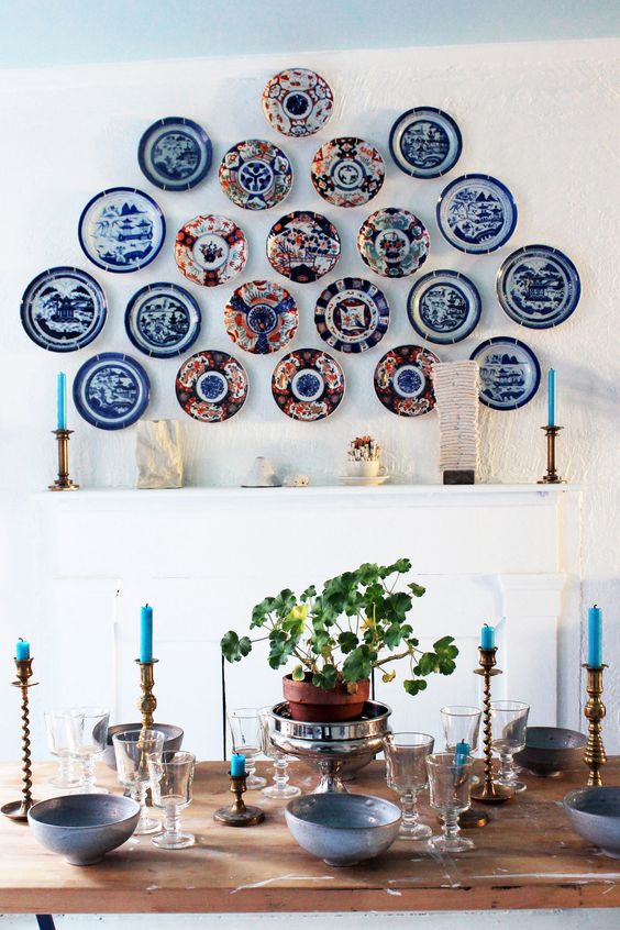a bold blue plate wall with exquisite vintage plates over the mantel that bring interest and character to the dining room