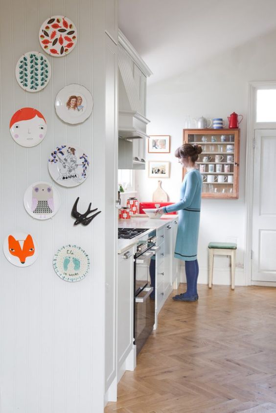 a plate wall of fun and cute plates is a cool and quirky decoration for the kitchen