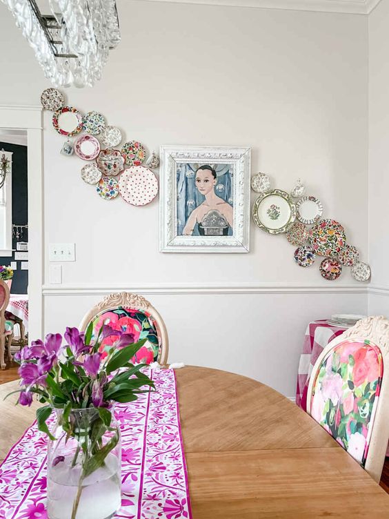 a plate wall with colorful plates and a quirky portrait is a unique wall decoration that brings interest to the space