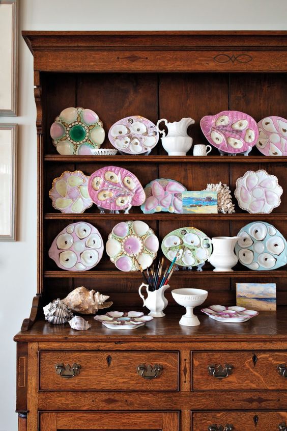 a stained buffet with a plate wall of oyster plates is a cool solution for a coastal dining room or kitchen