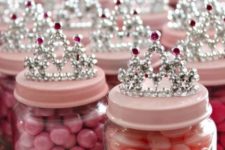04 candies in jars with pink lids and crowns on top for a princess-themed baby shower