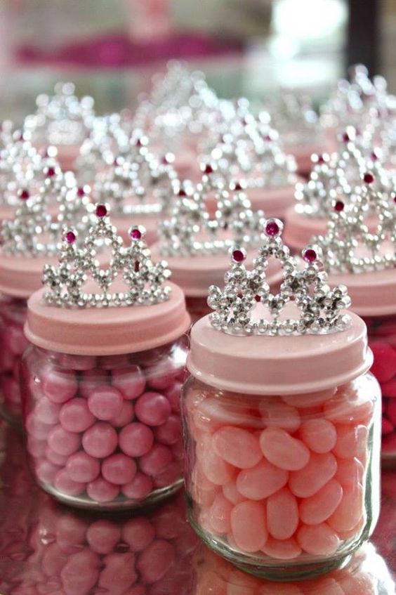 candies in jars with pink lids and crowns on top for a princess-themed baby shower