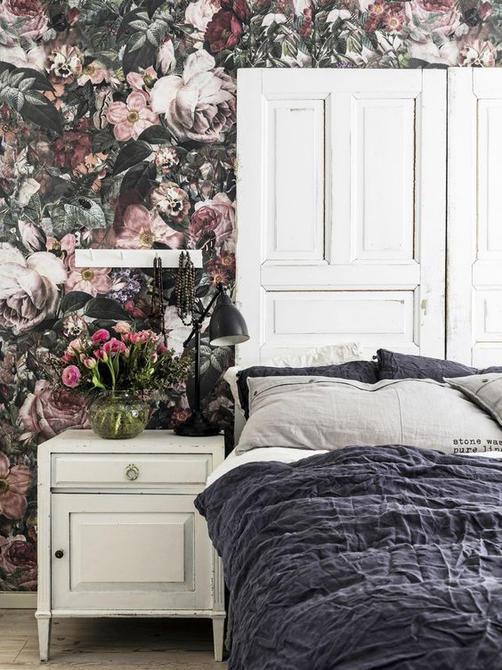 moody wallpaper and a headboard made of old doors for a refined feel
