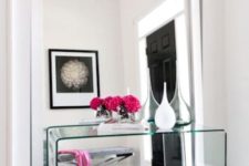 06 a modern mirror with no frame takes the whole wall and a glass console complements the look