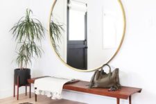 07 a large scale round mirror in a gilded frame adds a glam feel