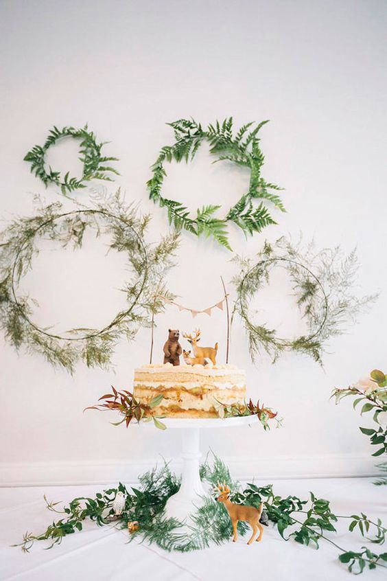 greenery wreaths as a dessert table backdrop and some greenery for the cake display