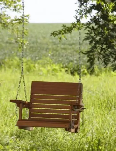 an old hanging wooden chair repurposed into a comfy and simple swing