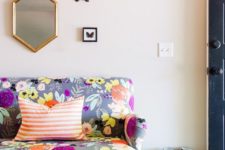 11 a small sofa with grey upholstery and bold floral prints