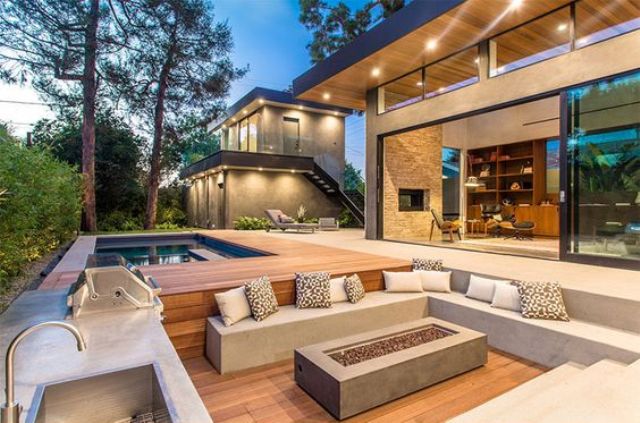 a sunken modern conversation pit with an ethanol fireplace and a barbeque