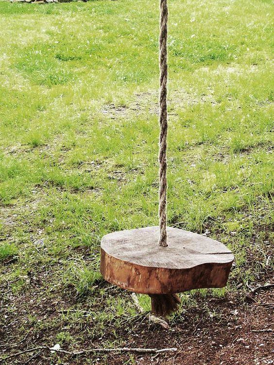 a simple swing of a wooden slice and rope for standing or sitting